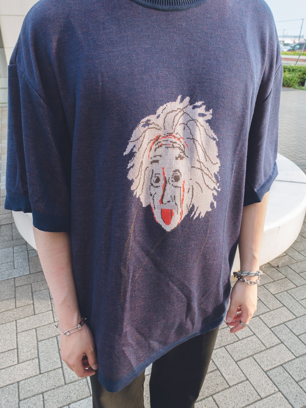 ブラック系のスラックス、パープル系のトップス、ブラック系のシューズを着用したメンズの夏コーディネートの2枚目の写真