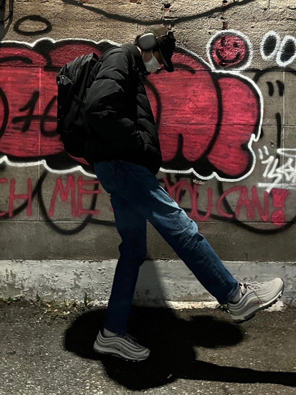 ブルー系のデニムパンツ、ブラック系のダウンジャケット/コート、ブラック系のバックパック/リュックを着用したメンズの秋コーディネートの3枚目の写真