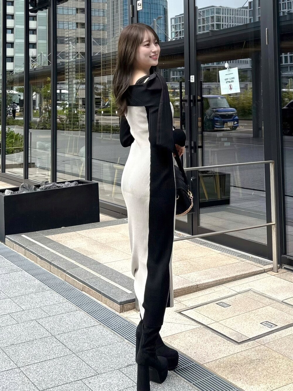 ベージュ系のワンピース、ブラック系のショルダーバッグ、ブラック系のブーツを着用したレディースの秋コーディネートの3枚目の写真