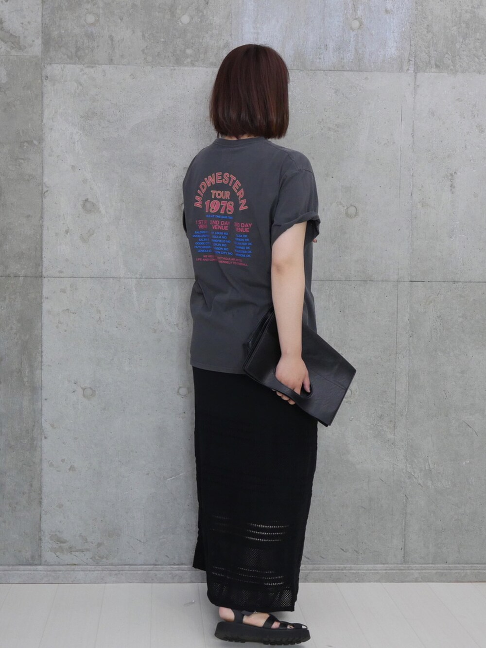 グレー系のTシャツ/カットソー、ブラック系のスカート、ブラック系のサンダルを着用したレディースの夏コーディネートの2枚目の写真