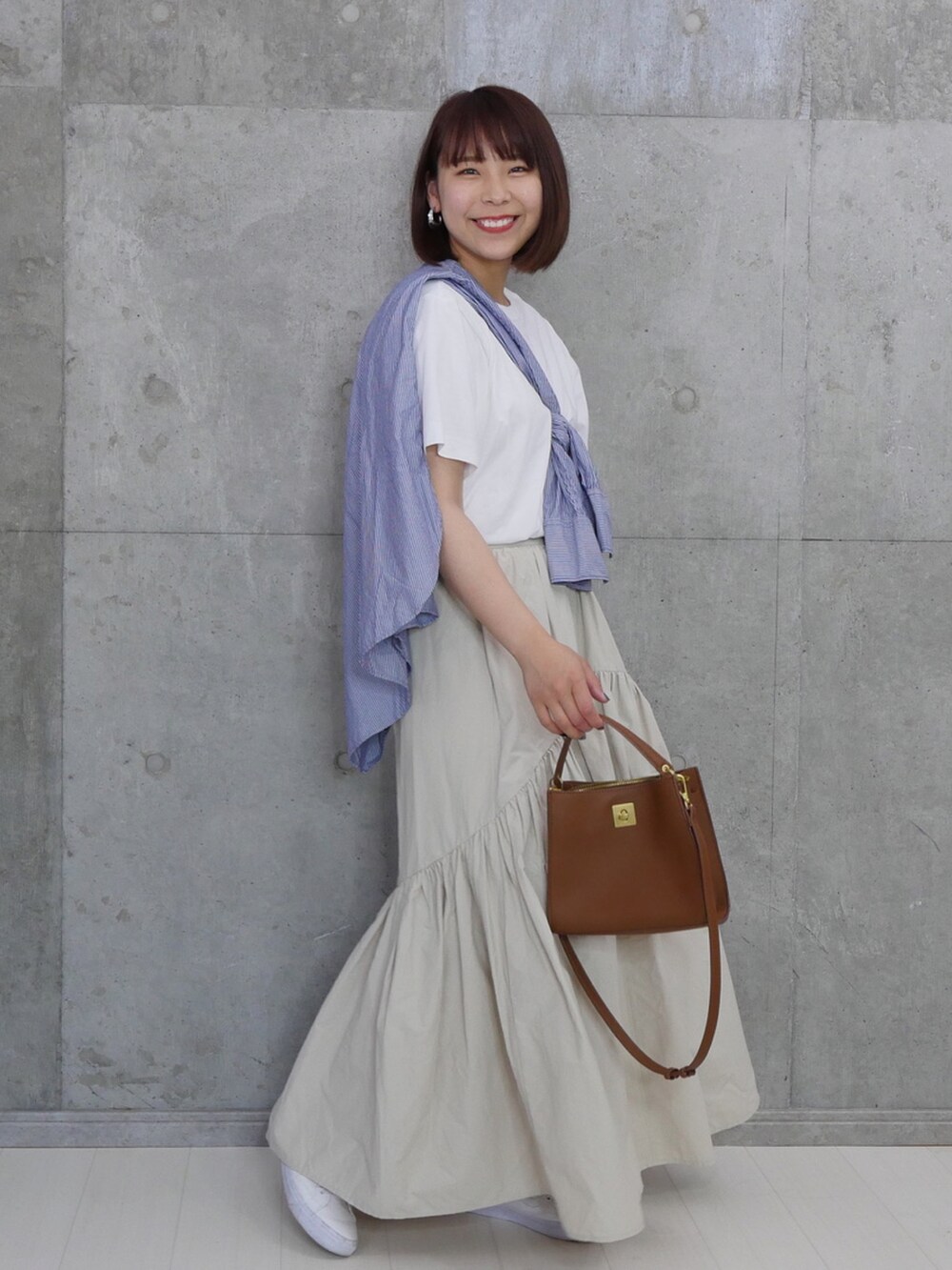ブラウン系のバッグ、ブルー系のシャツ/ブラウス、ホワイト系のTシャツ/カットソーを着用したレディースの夏コーディネートの3枚目の写真