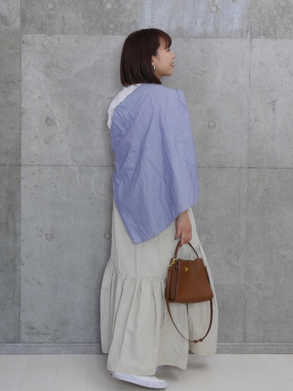 ブラウン系のバッグ、ブルー系のシャツ/ブラウス、ホワイト系のTシャツ/カットソーを着用したレディースの夏コーディネートの2枚目の写真