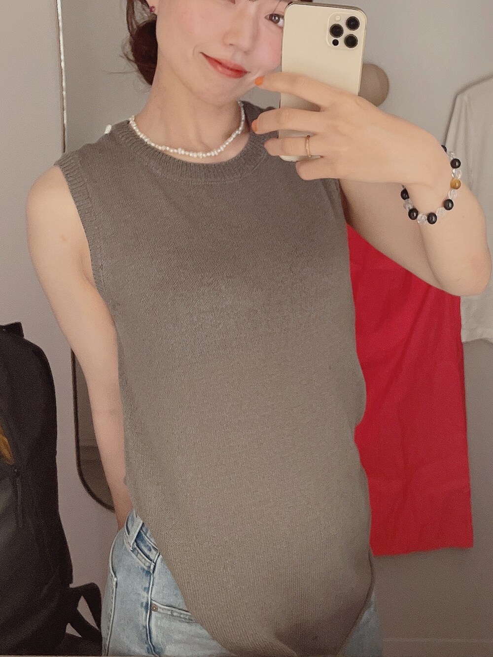 ブルー系のデニムパンツ、グレー系のトップス、ブラック系のバッグを着用したレディースの夏コーディネートの2枚目の写真