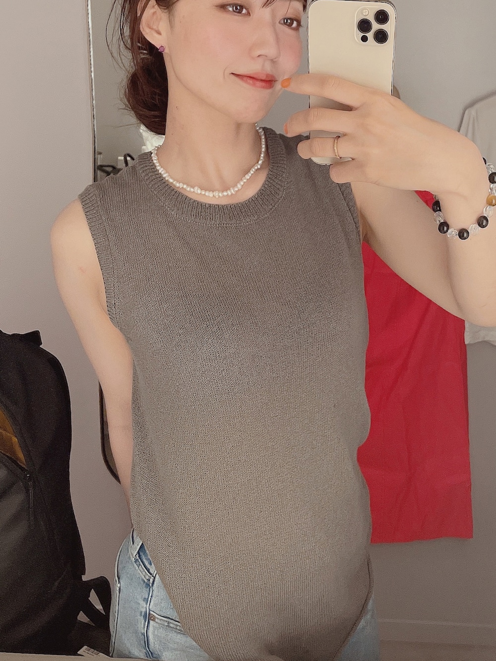 ブルー系のデニムパンツ、グレー系のトップス、ブラック系のバッグを着用したレディースの夏コーディネートの3枚目の写真