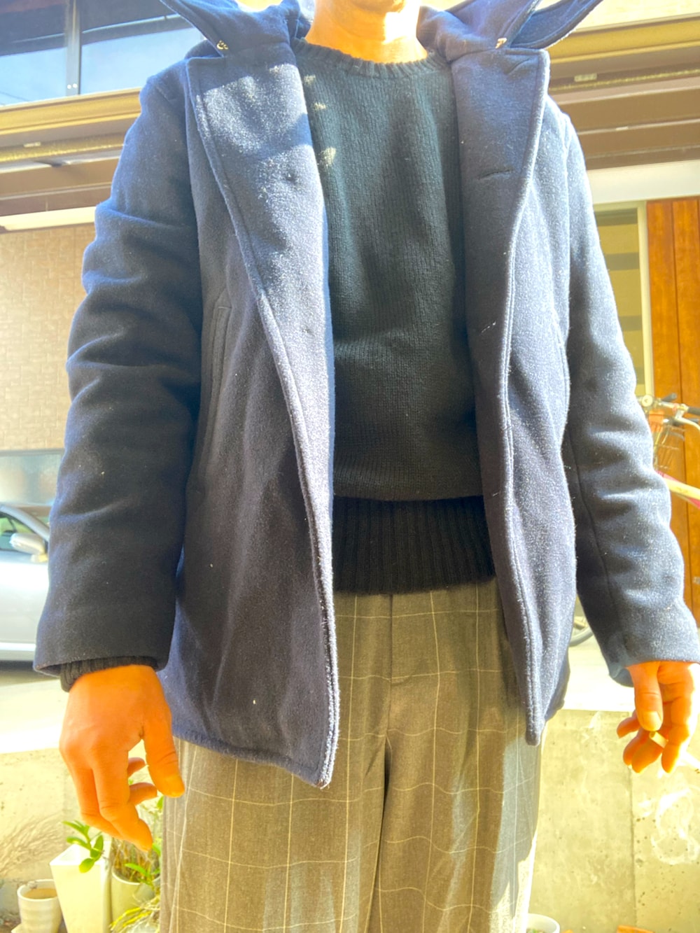 ブルー系のダッフルコート、ブラック系のニット/セーター、グレー系のスラックスを着用したメンズの冬コーディネートの3枚目の写真