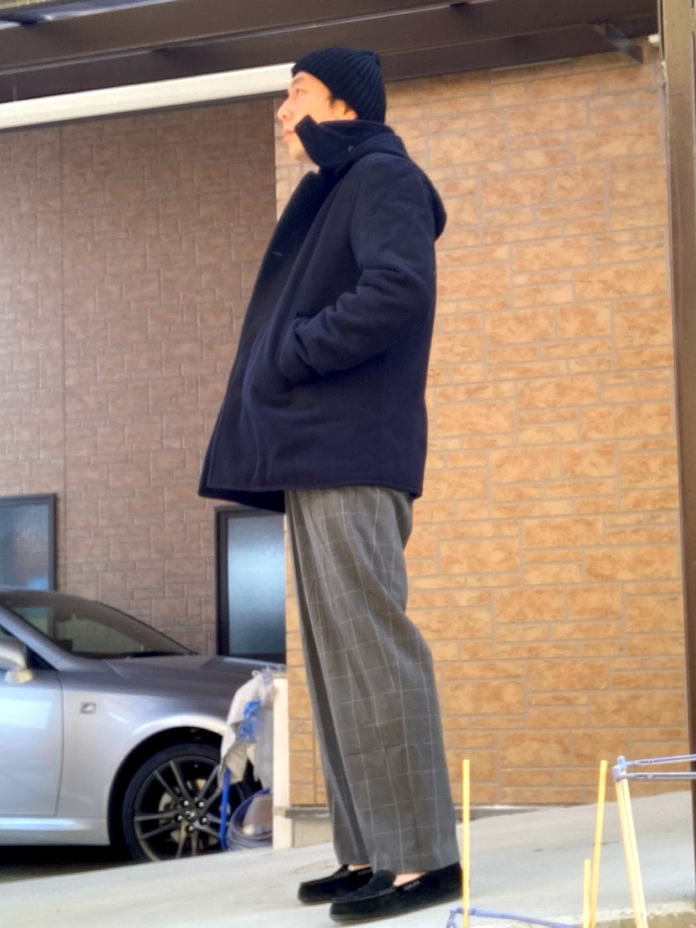 ブルー系のダッフルコート、ブラック系のニット/セーター、グレー系のスラックスを着用したメンズの冬コーディネートの2枚目の写真