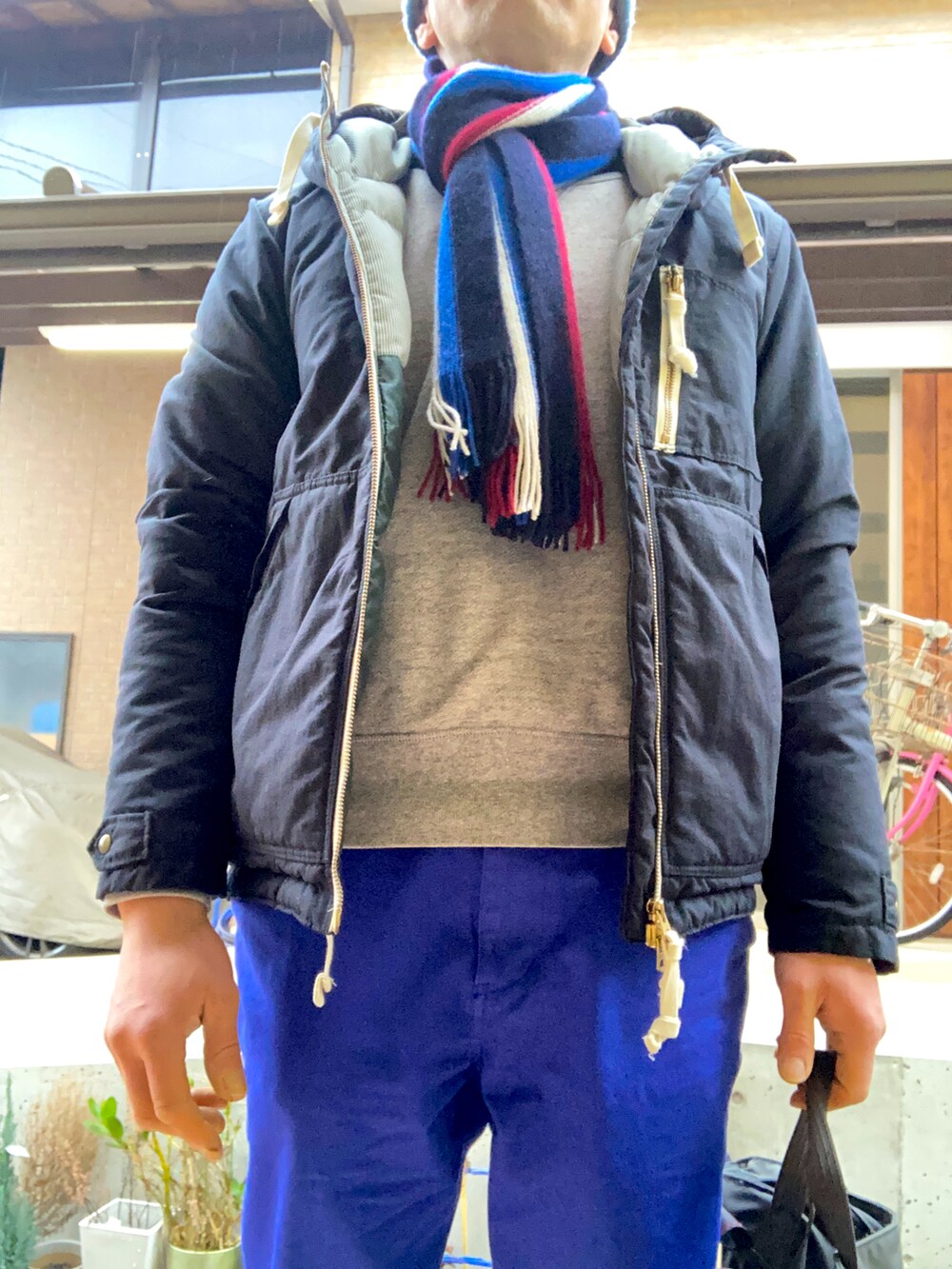 ブラック系のダウンジャケット/コート、パープル系のチノパンツ、グレー系のトートバッグを着用したメンズの冬コーディネートの2枚目の写真