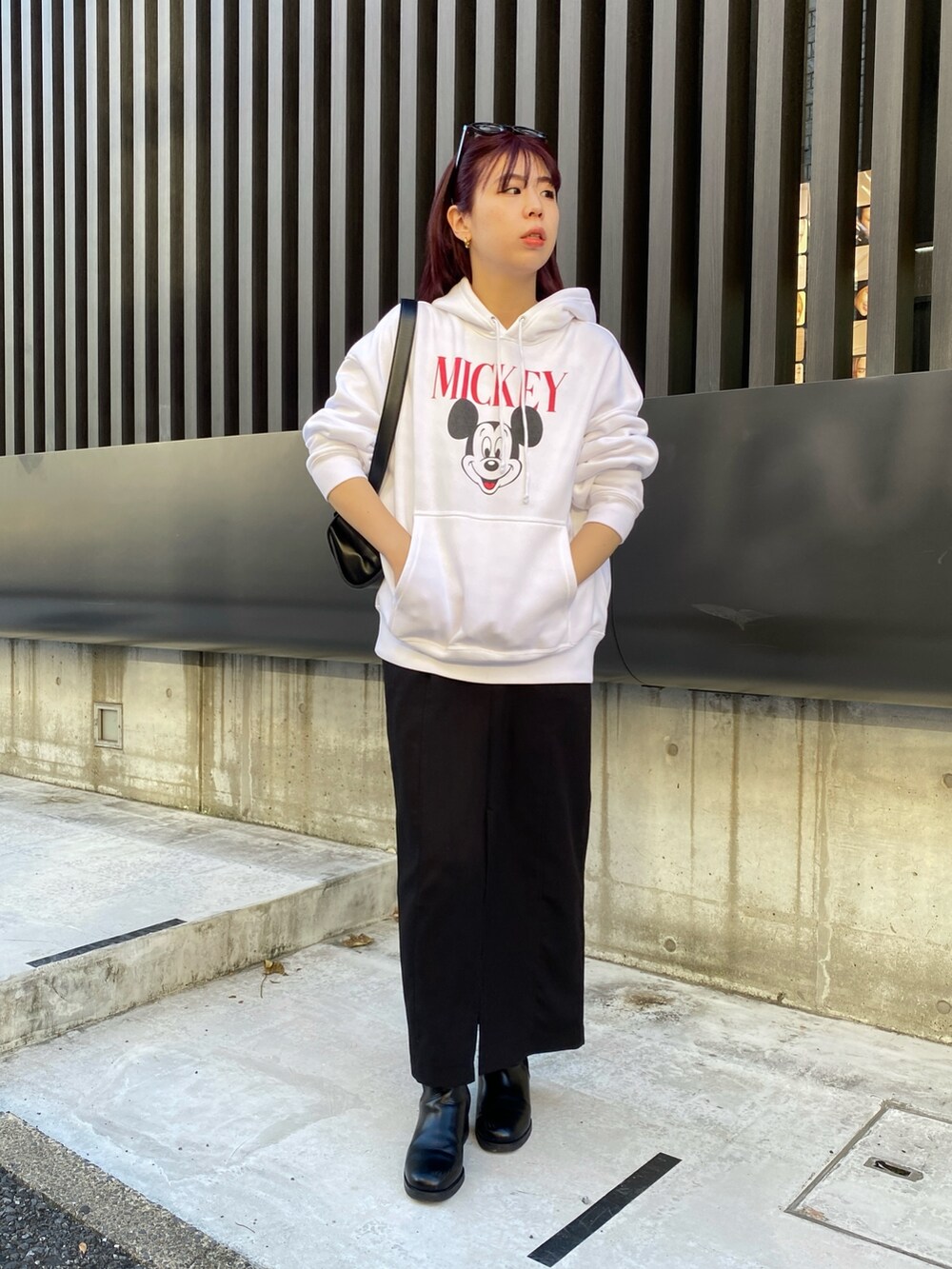 ホワイト系のパーカー、ブラック系のスカート、ベージュ系のショルダーバッグを着用したレディースの冬コーディネートの2枚目の写真