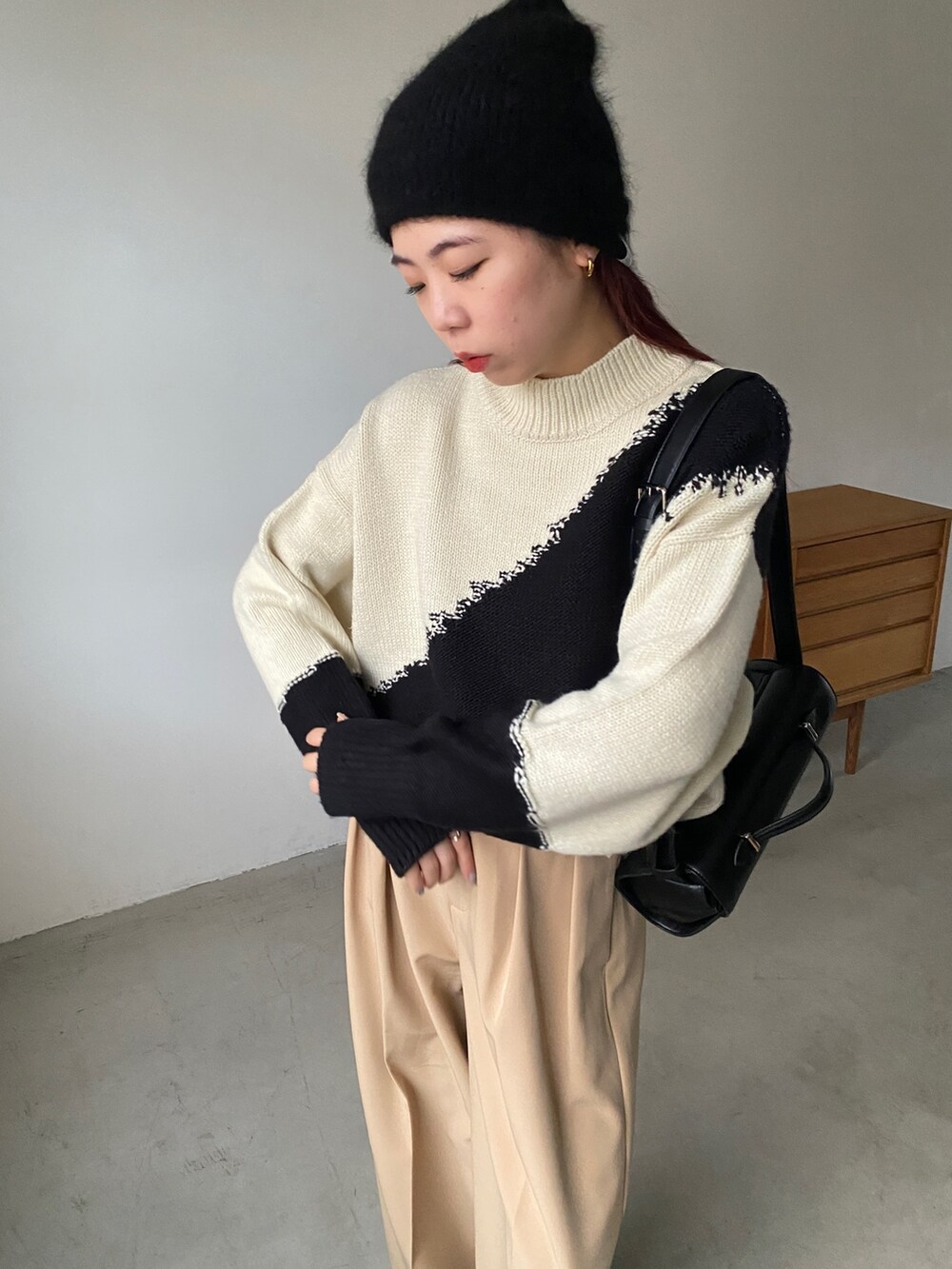ホワイト系のニット/セーター、ベージュ系のその他パンツ、ブラック系のその他シューズを着用したレディースの秋コーディネートの4枚目の写真
