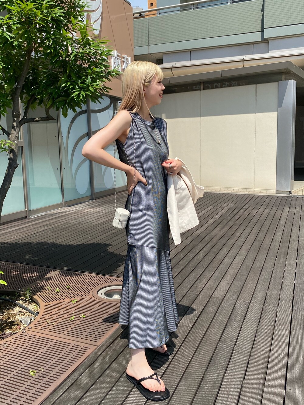ブラック系のワンピース、ホワイト系のベスト、ホワイト系のショルダーバッグを着用したレディースの夏コーディネートの3枚目の写真