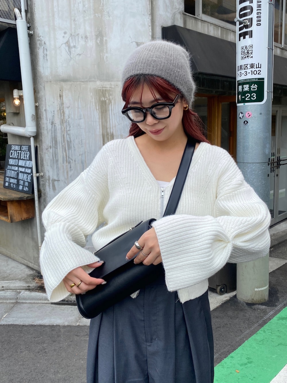 グレー系のパンツ、ブルー系のスニーカー、ブラック系のショルダーバッグを着用したレディースの秋コーディネートの6枚目の写真