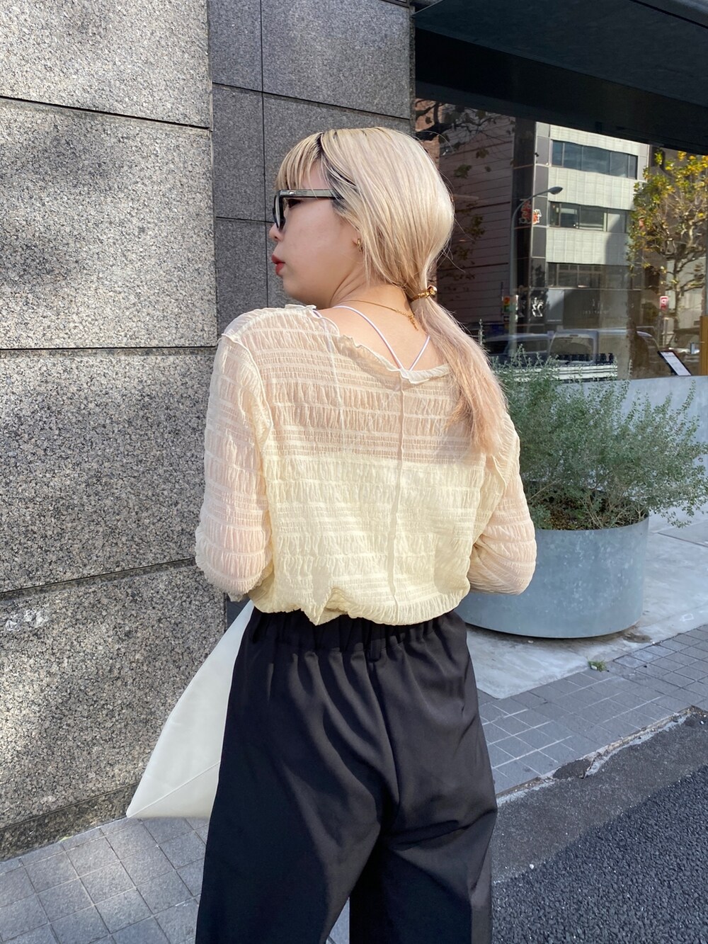 ベージュ系のTシャツ/カットソー、ブラック系のその他パンツ、ホワイト系のサンダルを着用したレディースの冬コーディネートの5枚目の写真