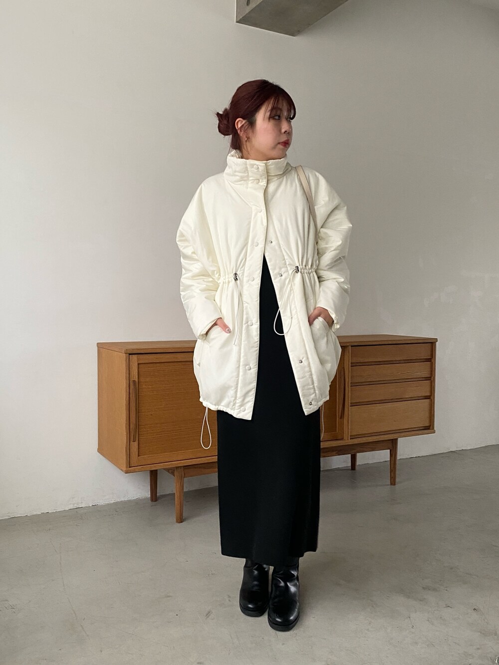 ホワイト系のその他アウター、ブラック系のワンピース、ブラック系のブーツを着用したレディースの冬コーディネートの2枚目の写真