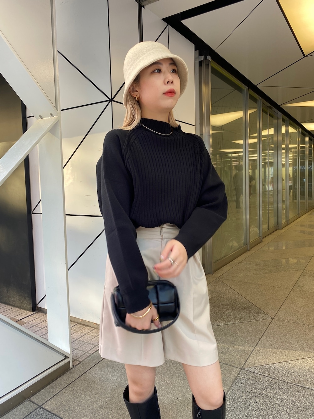 ブラック系のニット/セーター、ブラック系のブーツ、ブラック系のトートバッグを着用したレディースの冬コーディネートの4枚目の写真