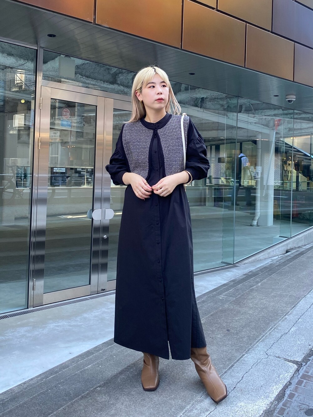 ブラック系のニット/セーター、ブラック系のワンピース、ブラウン系のブーツを着用したレディースの夏コーディネートの2枚目の写真