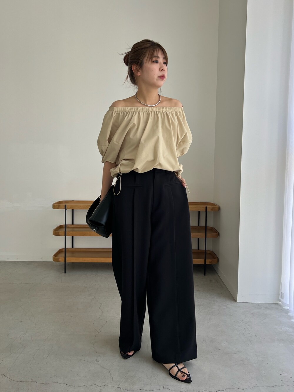 ベージュ系のシャツ/ブラウス、ブラック系のパンツ、ブラック系のブーツを着用したレディースの夏コーディネートの3枚目の写真