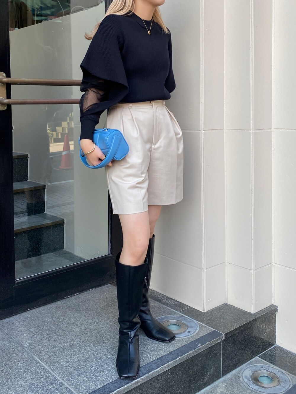 ブラック系のニット/セーター、ホワイト系のその他パンツ、ブラック系のブーツを着用したレディースの冬コーディネートの2枚目の写真