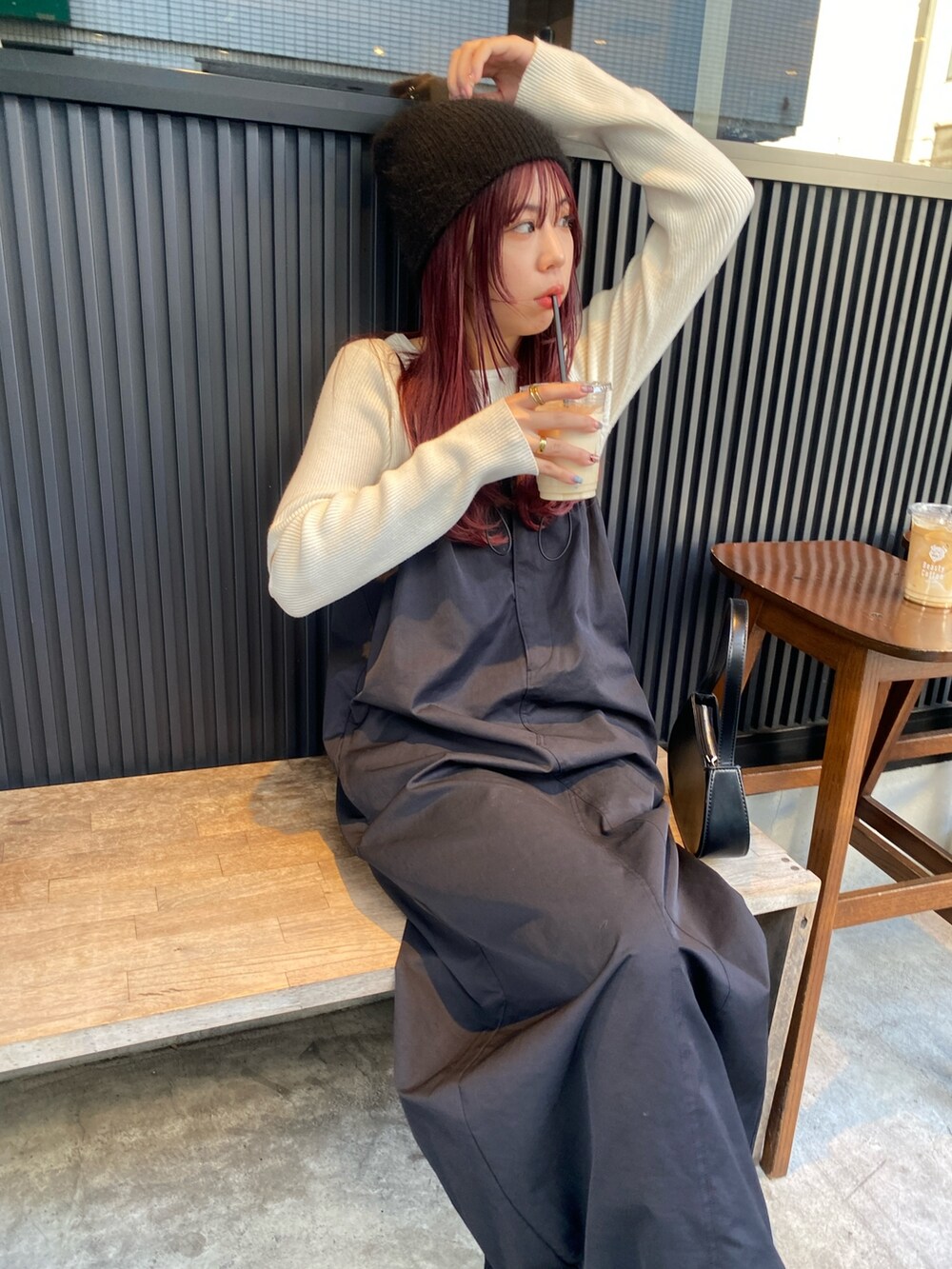 ホワイト系のニット/セーター、ブラック系のワンピース/ドレス、ブラック系のスニーカーを着用したレディースの秋コーディネートの5枚目の写真