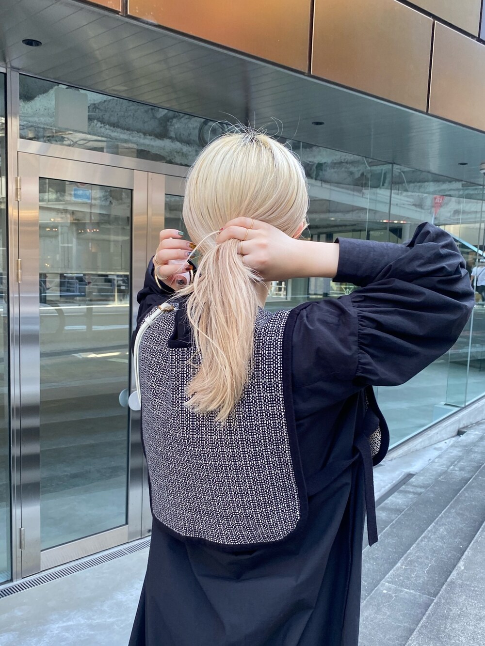 ブラック系のニット/セーター、ブラック系のワンピース、ブラウン系のブーツを着用したレディースの夏コーディネートの4枚目の写真