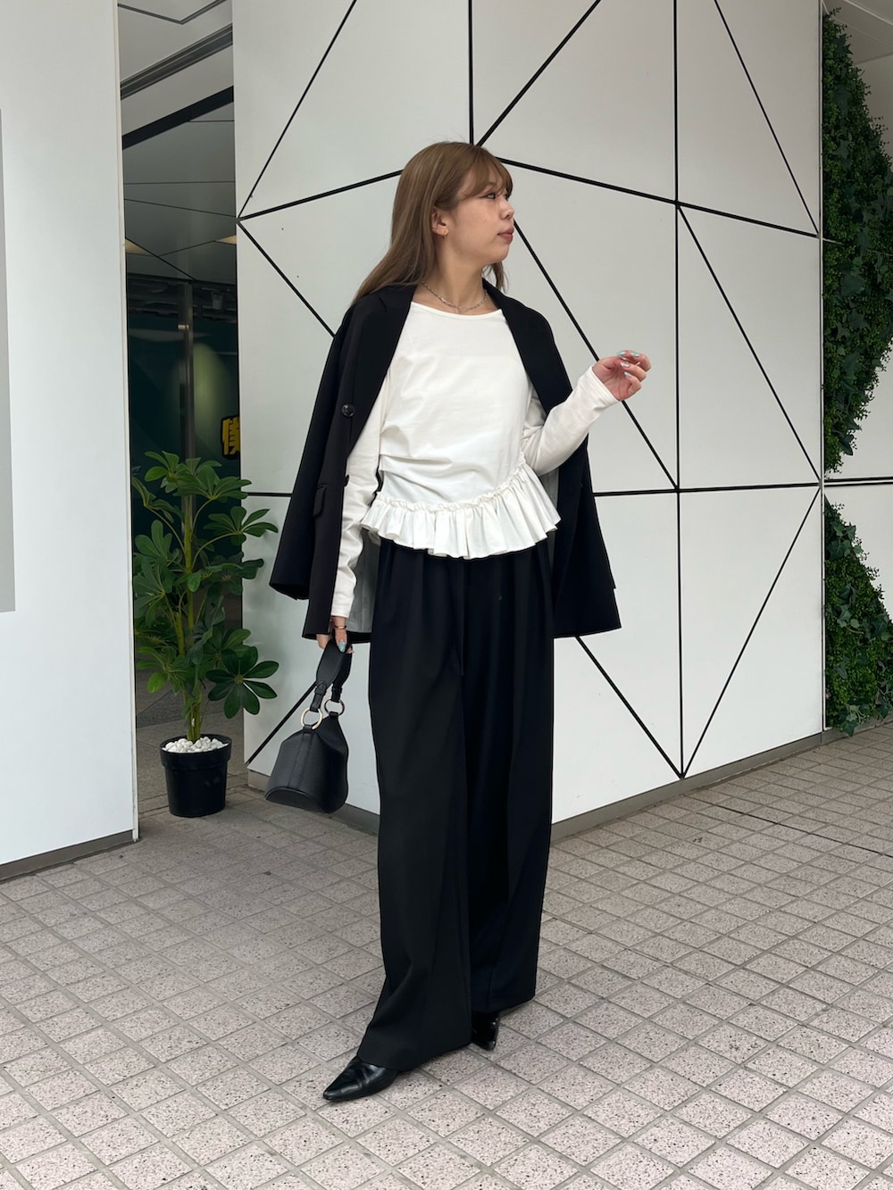 ブラック系のテーラードジャケット、ホワイト系のTシャツ/カットソー、ブラック系のその他パンツを着用したレディースの春コーディネートの2枚目の写真