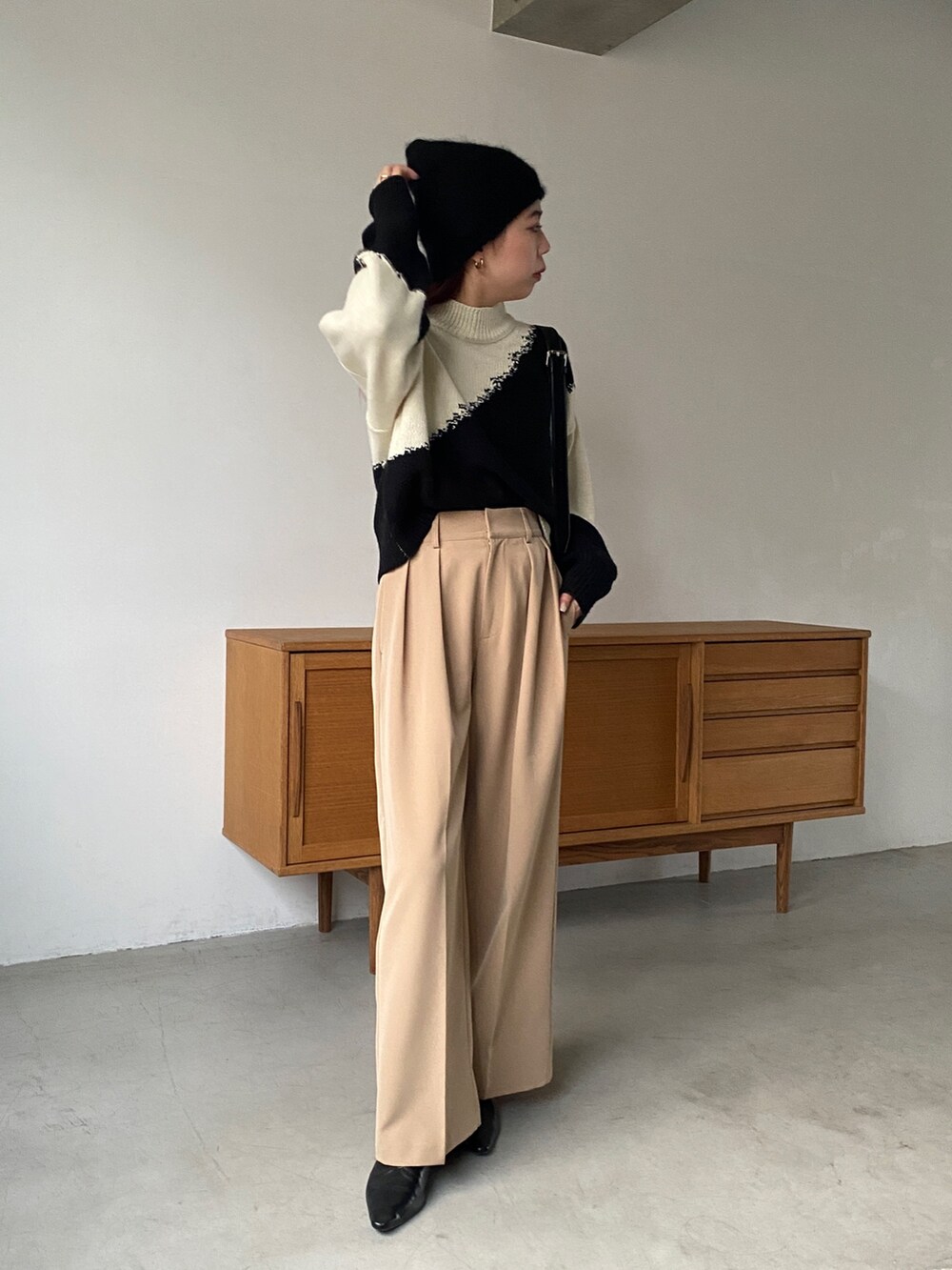 ホワイト系のニット/セーター、ベージュ系のその他パンツ、ブラック系のその他シューズを着用したレディースの秋コーディネートの2枚目の写真