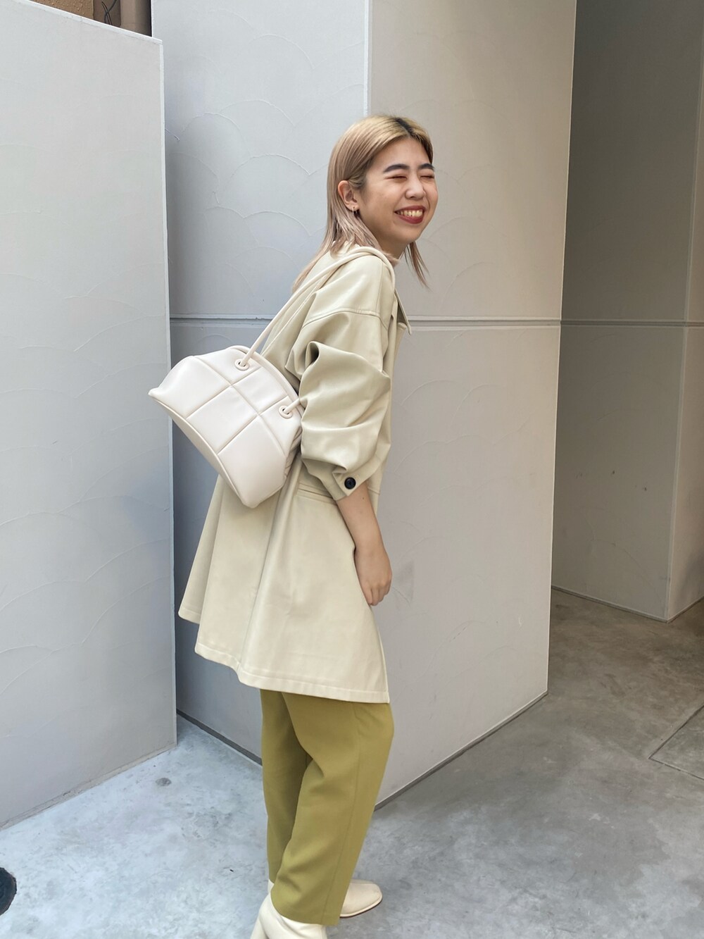 ベージュ系のカバーオール、イエロー系のその他パンツ、ホワイト系のブーツを着用したレディースの冬コーディネートの4枚目の写真