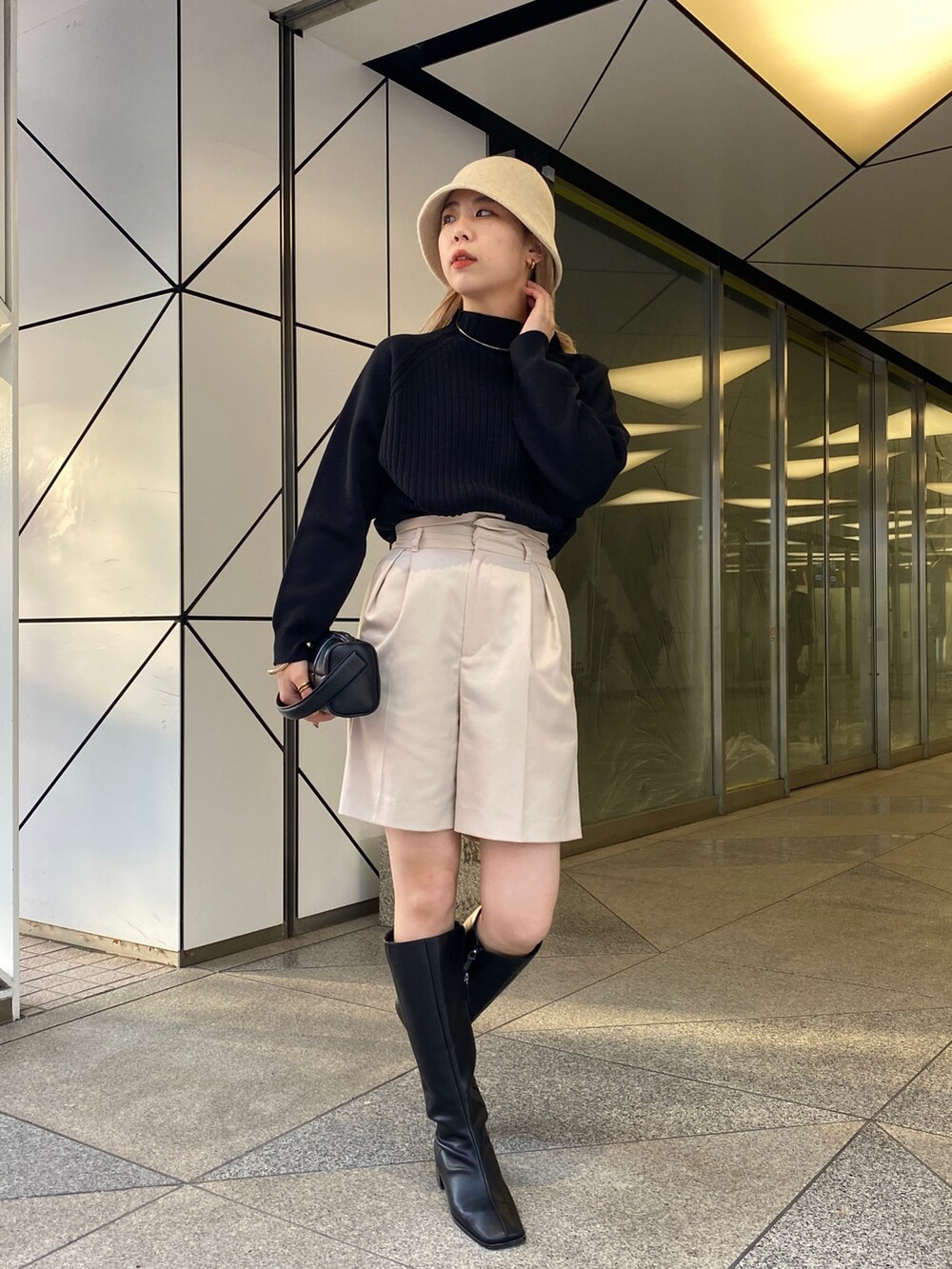 ブラック系のニット/セーター、ブラック系のブーツ、ブラック系のトートバッグを着用したレディースの冬コーディネートの3枚目の写真