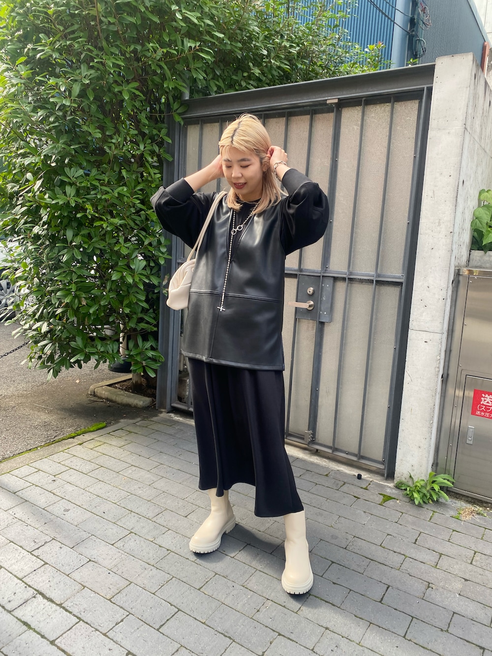 ブラック系のワンピース、ブラック系のベスト、ホワイト系のブーツを着用したレディースの秋コーディネートの2枚目の写真