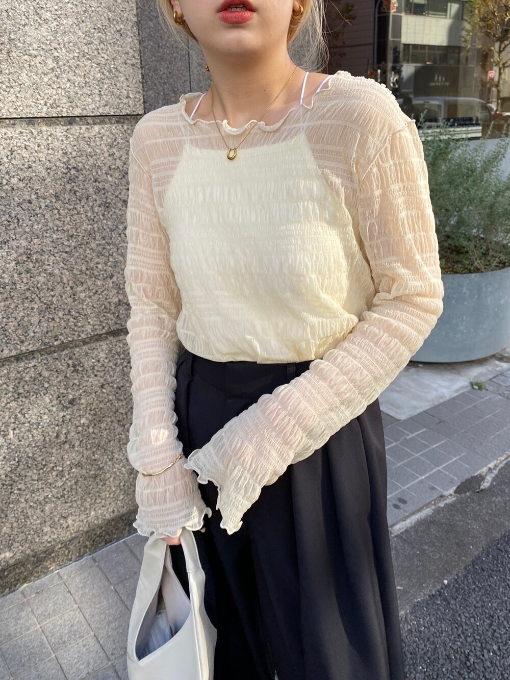 ベージュ系のTシャツ/カットソー、ブラック系のその他パンツ、ホワイト系のサンダルを着用したレディースの冬コーディネートの4枚目の写真