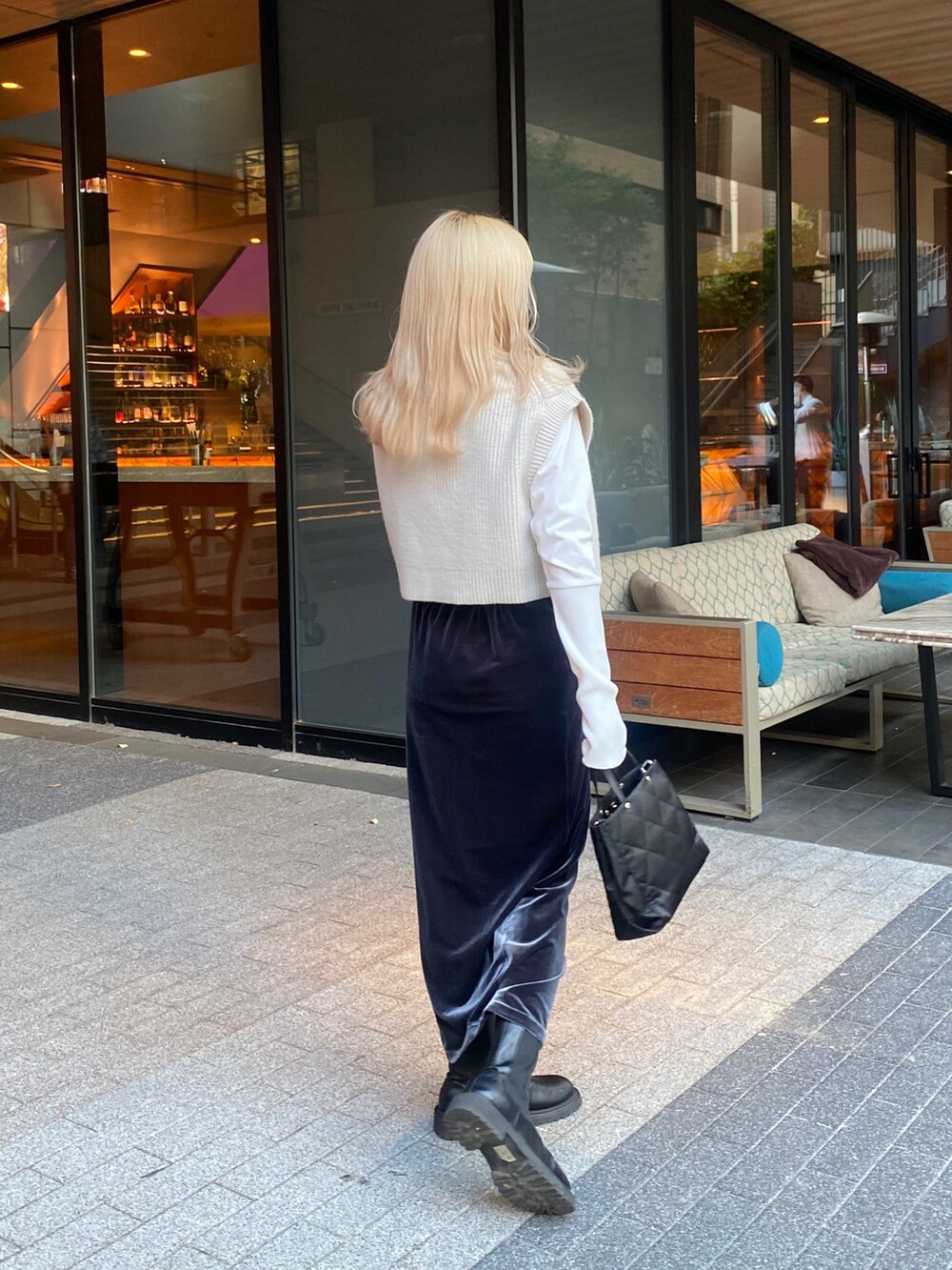 グレー系のスカート、ホワイト系のベスト、ホワイト系のTシャツ/カットソーを着用したレディースの秋コーディネートの3枚目の写真