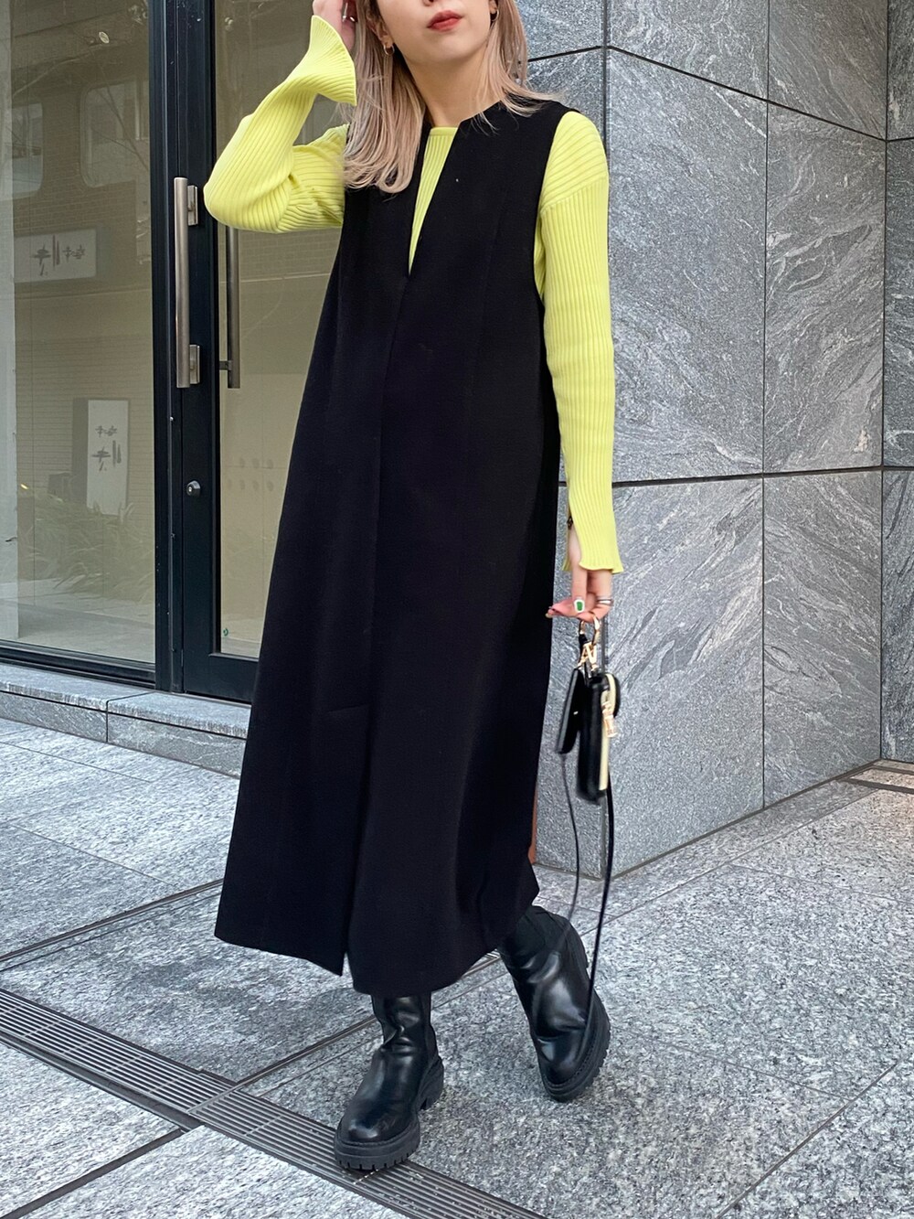 ブラック系のワンピース、ブラック系のブーツ、ブラック系のショルダーバッグを着用したレディースの冬コーディネートの2枚目の写真