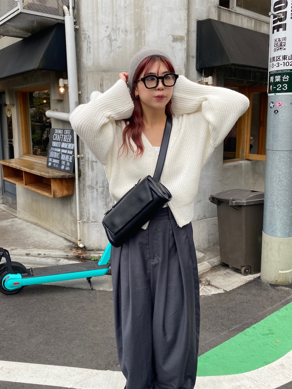 グレー系のパンツ、ブルー系のスニーカー、ブラック系のショルダーバッグを着用したレディースの秋コーディネートの4枚目の写真