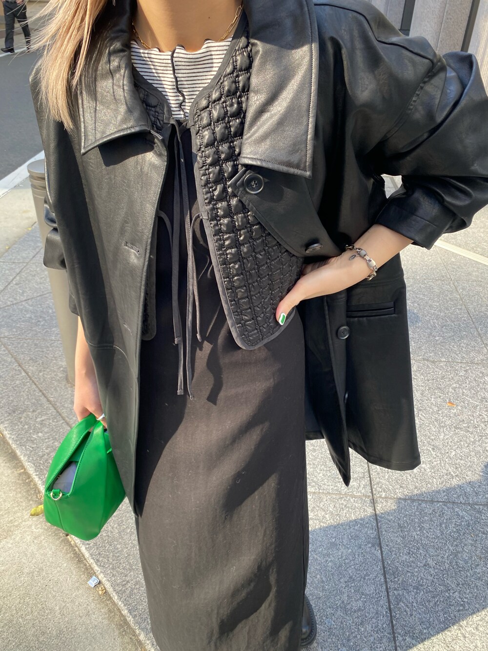 ブラック系のカバーオール、ブラック系のベスト、ブラック系のワンピースを着用したレディースの冬コーディネートの3枚目の写真