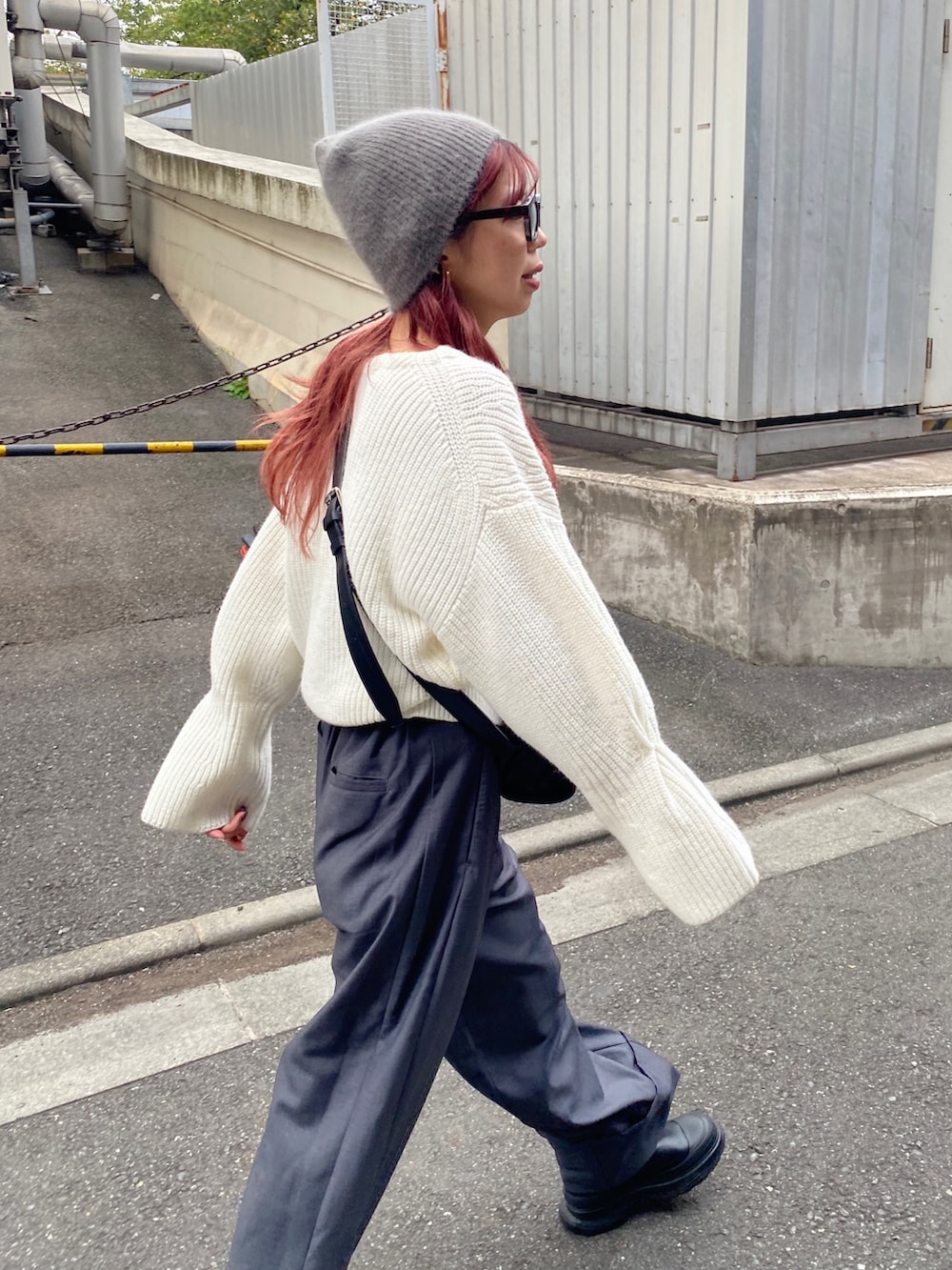 グレー系のパンツ、ブルー系のスニーカー、ブラック系のショルダーバッグを着用したレディースの秋コーディネートの5枚目の写真