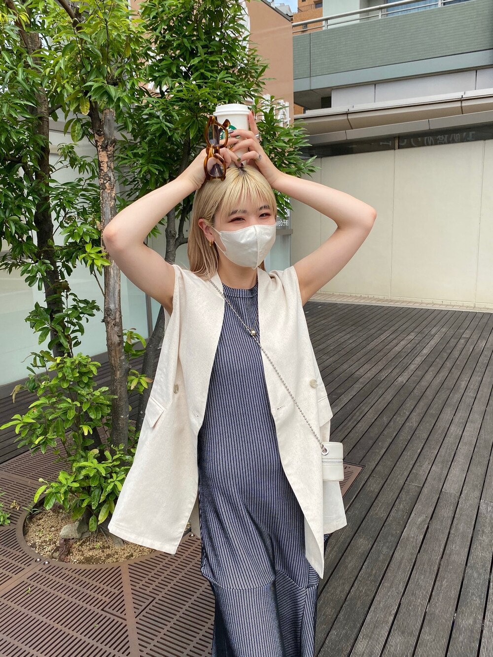 ブラック系のワンピース、ホワイト系のベスト、ホワイト系のショルダーバッグを着用したレディースの夏コーディネートの5枚目の写真