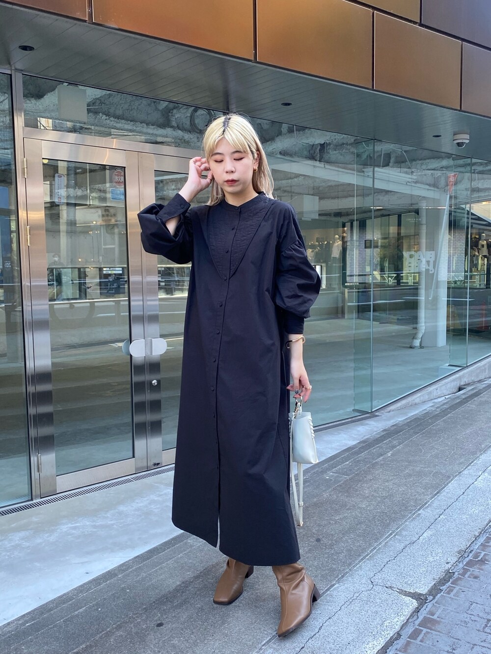 ブラック系のニット/セーター、ブラック系のワンピース、ブラウン系のブーツを着用したレディースの夏コーディネートの5枚目の写真