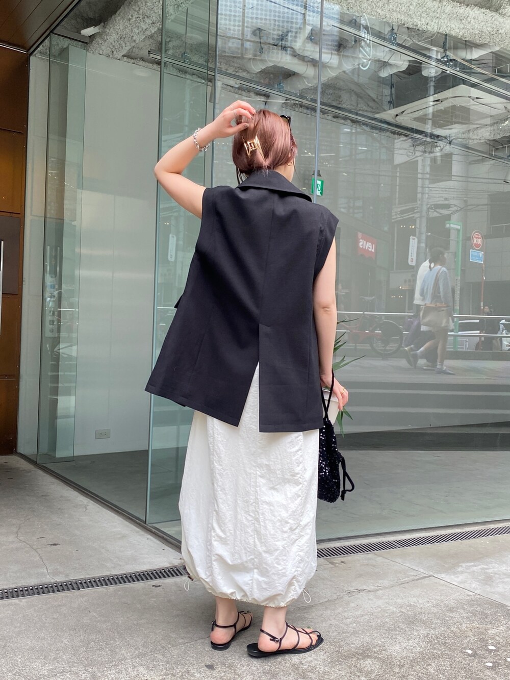 ブラック系のベスト、ホワイト系のワンピース、ブラック系のその他シューズを着用したレディースの春コーディネートの5枚目の写真