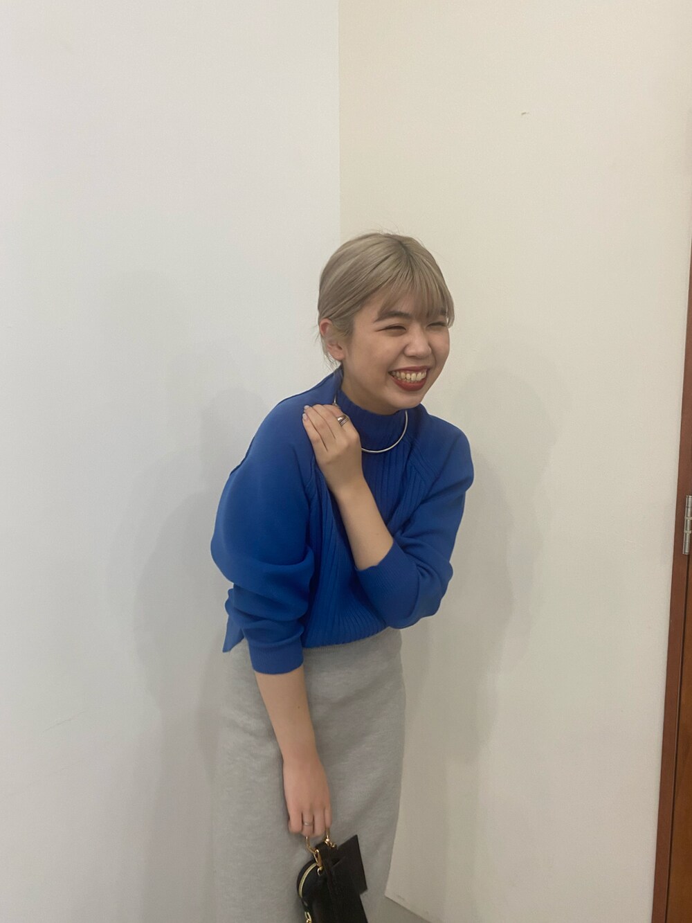 ブルー系のニット/セーター、ブラック系のブーツ、ブラック系のショルダーバッグを着用したレディースの冬コーディネートの3枚目の写真