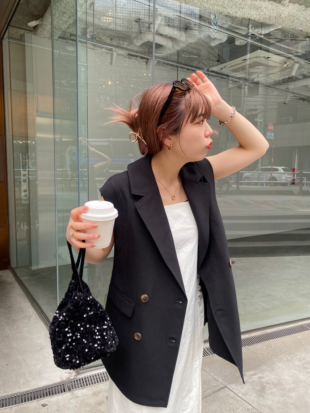 ブラック系のベスト、ホワイト系のワンピース、ブラック系のその他シューズを着用したレディースの春コーディネートの4枚目の写真