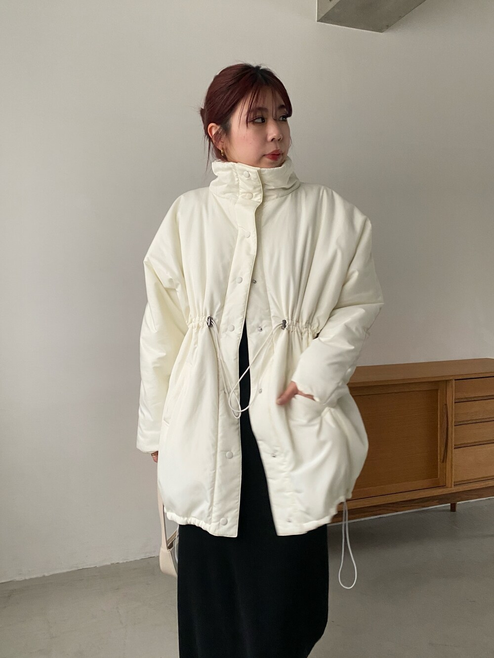 ホワイト系のその他アウター、ブラック系のワンピース、ブラック系のブーツを着用したレディースの冬コーディネートの4枚目の写真