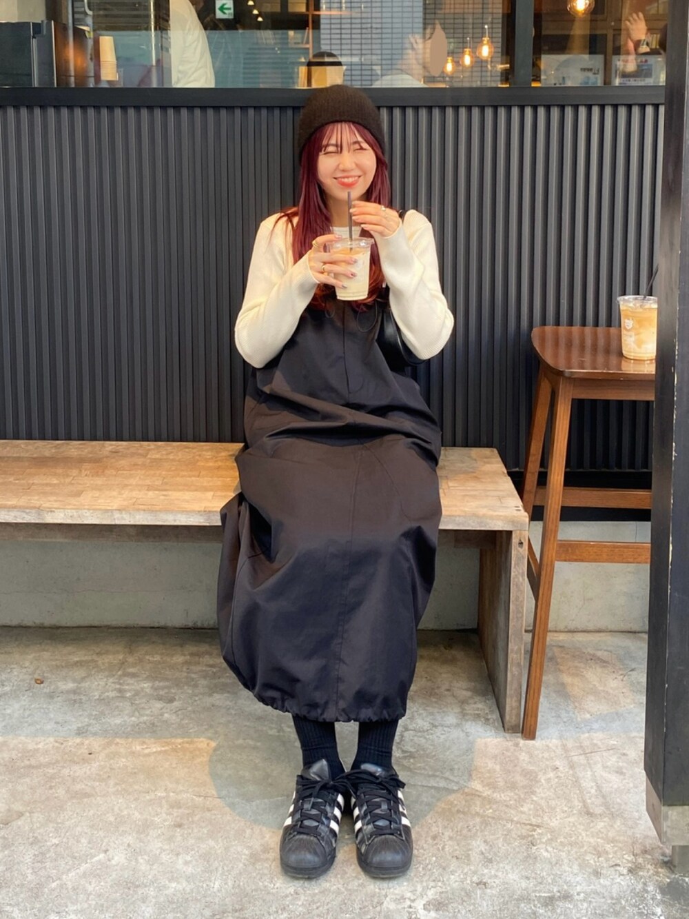 ホワイト系のニット/セーター、ブラック系のワンピース、ブラック系のスニーカーを着用したレディースの冬コーディネートの5枚目の写真