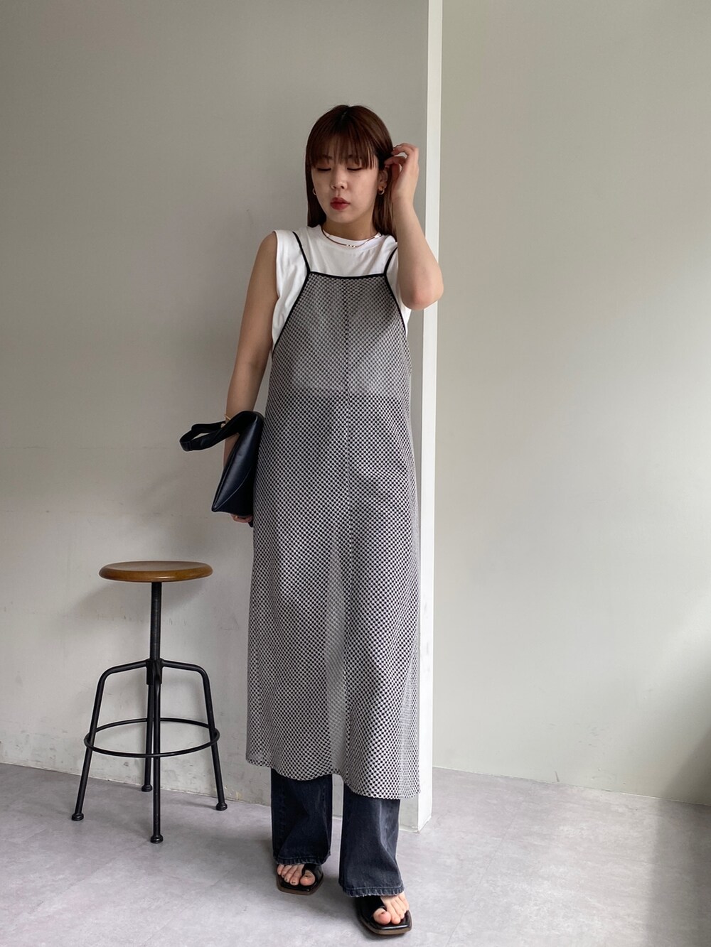 グレー系のワンピース/ドレス、ブラック系のデニムパンツ、ブラック系のシューズを着用したレディースの春コーディネートの3枚目の写真