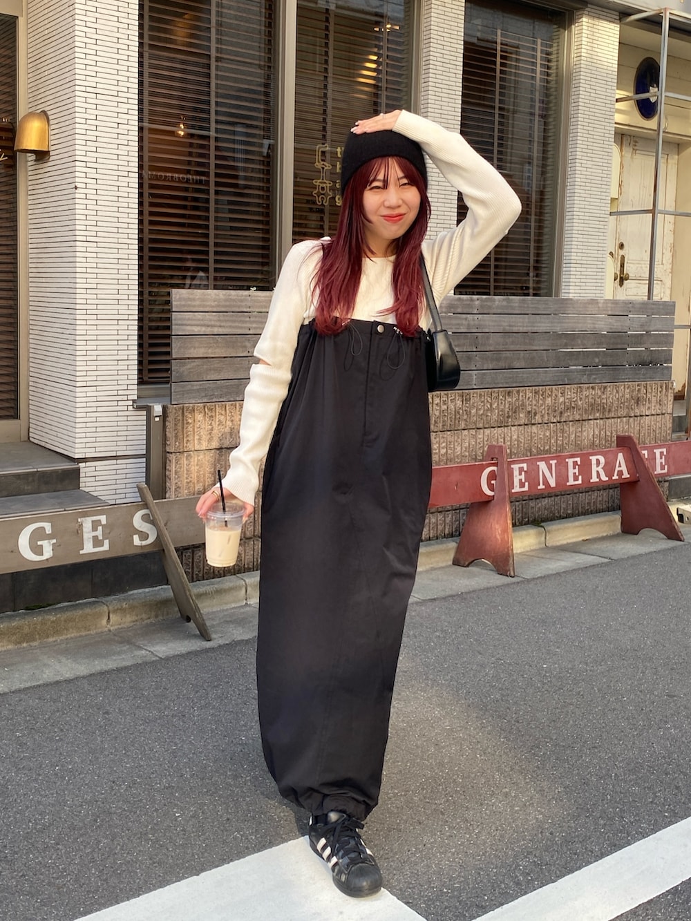 ホワイト系のニット/セーター、ブラック系のワンピース、ブラック系のスニーカーを着用したレディースの冬コーディネートの3枚目の写真