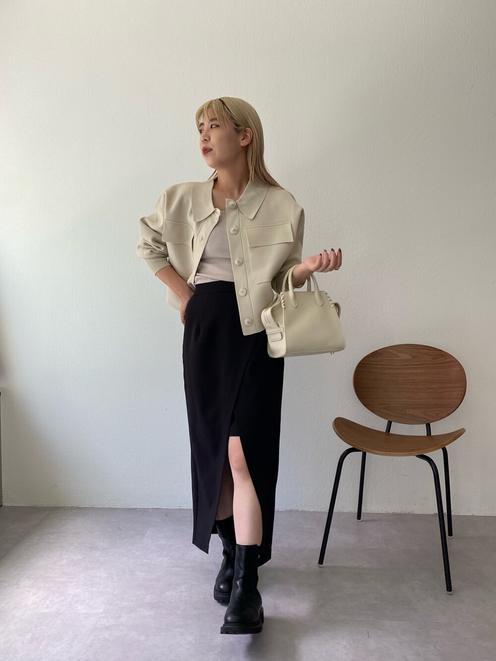 ホワイト系のブルゾン、ブラック系のブーツ、ホワイト系のトートバッグを着用したレディースの秋コーディネートの2枚目の写真