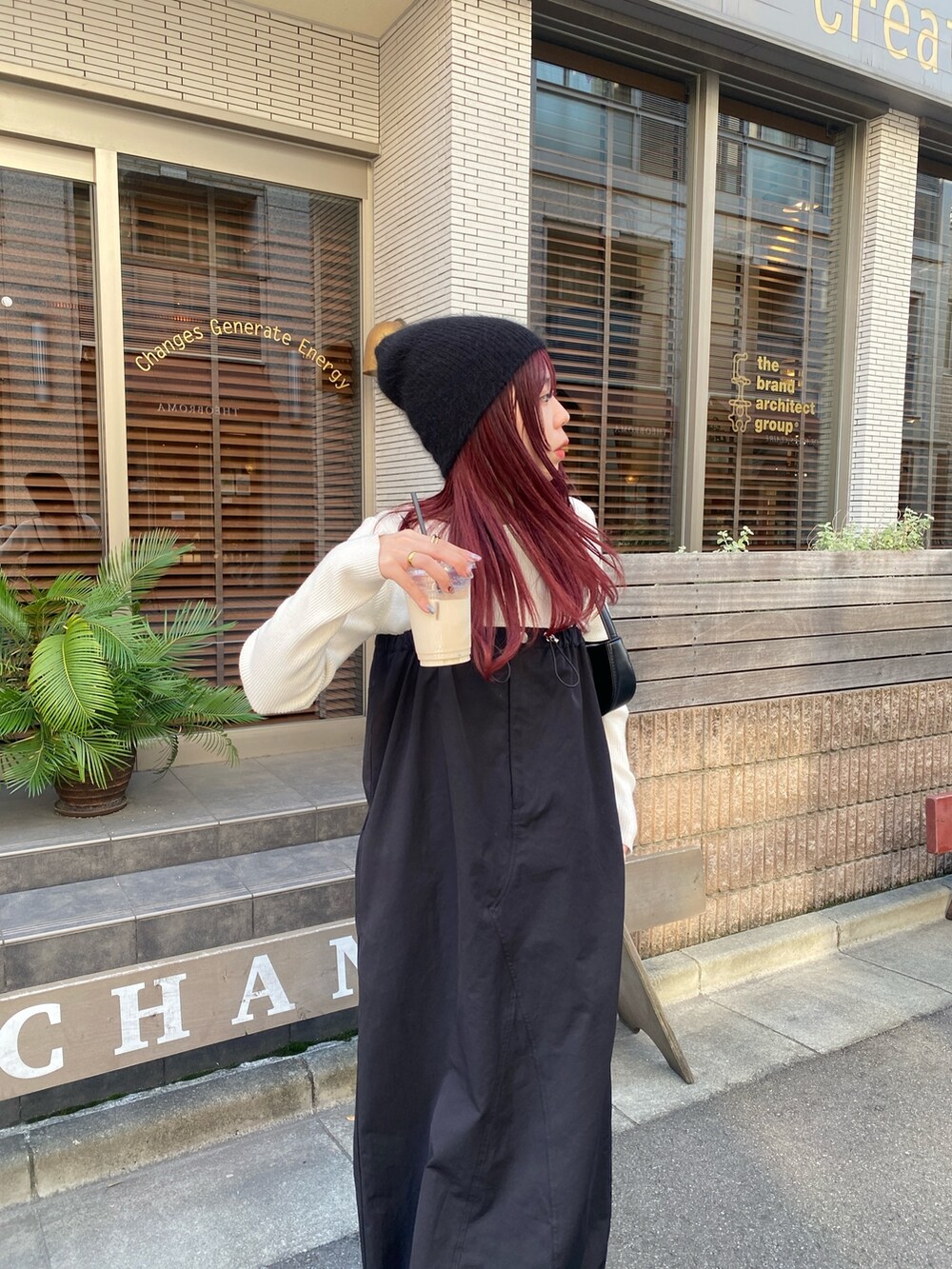 ホワイト系のニット/セーター、ブラック系のワンピース/ドレス、ブラック系のスニーカーを着用したレディースの秋コーディネートの4枚目の写真