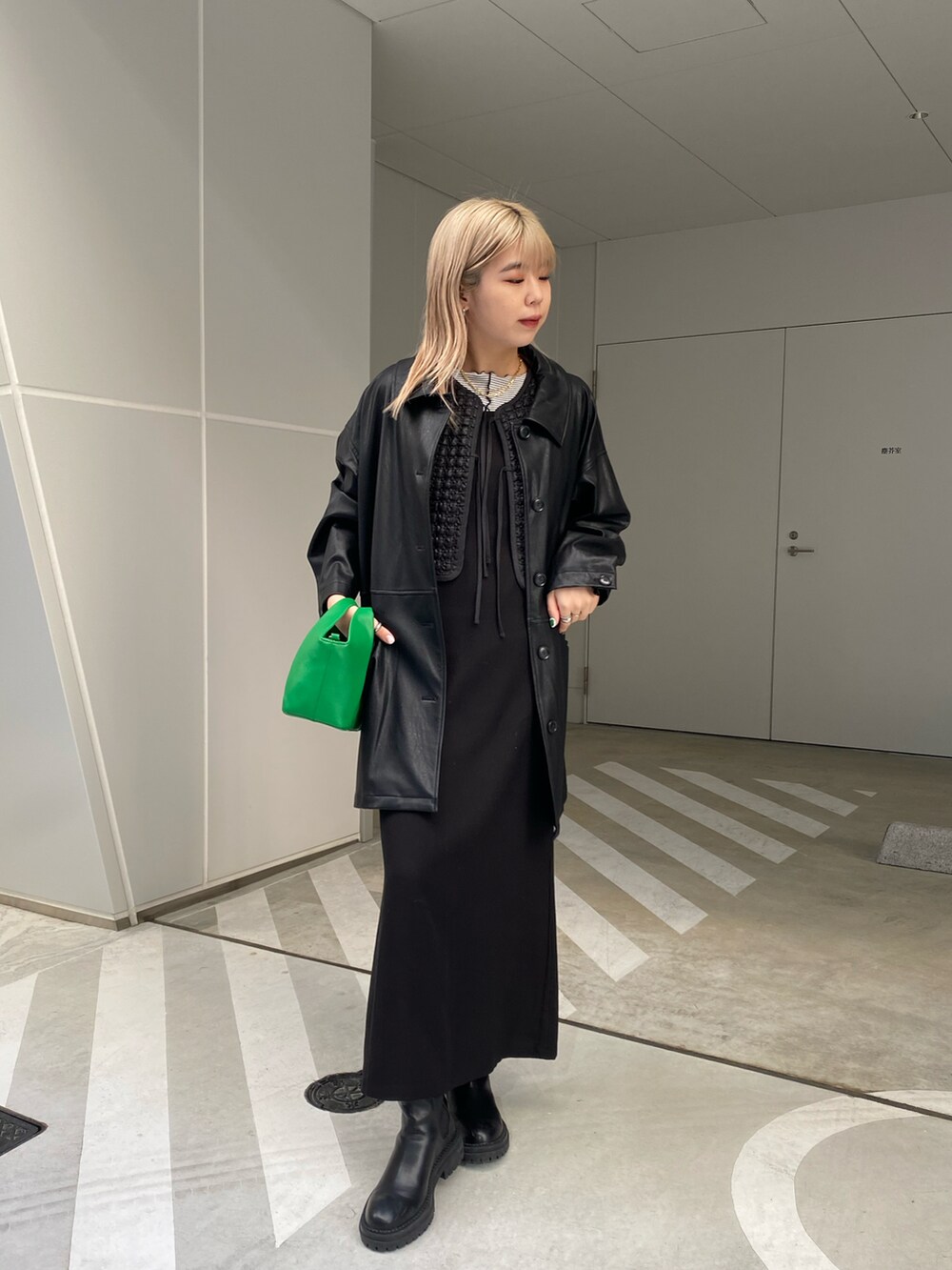 ブラック系のカバーオール、ブラック系のベスト、ブラック系のワンピースを着用したレディースの冬コーディネートの2枚目の写真