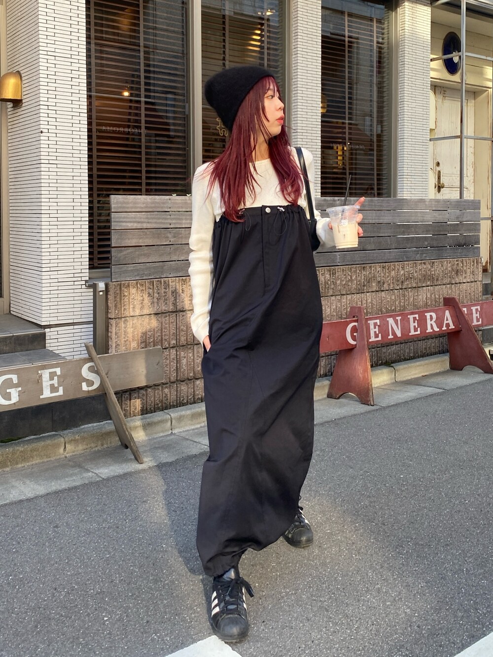 ホワイト系のニット/セーター、ブラック系のワンピース、ブラック系のスニーカーを着用したレディースの冬コーディネートの2枚目の写真