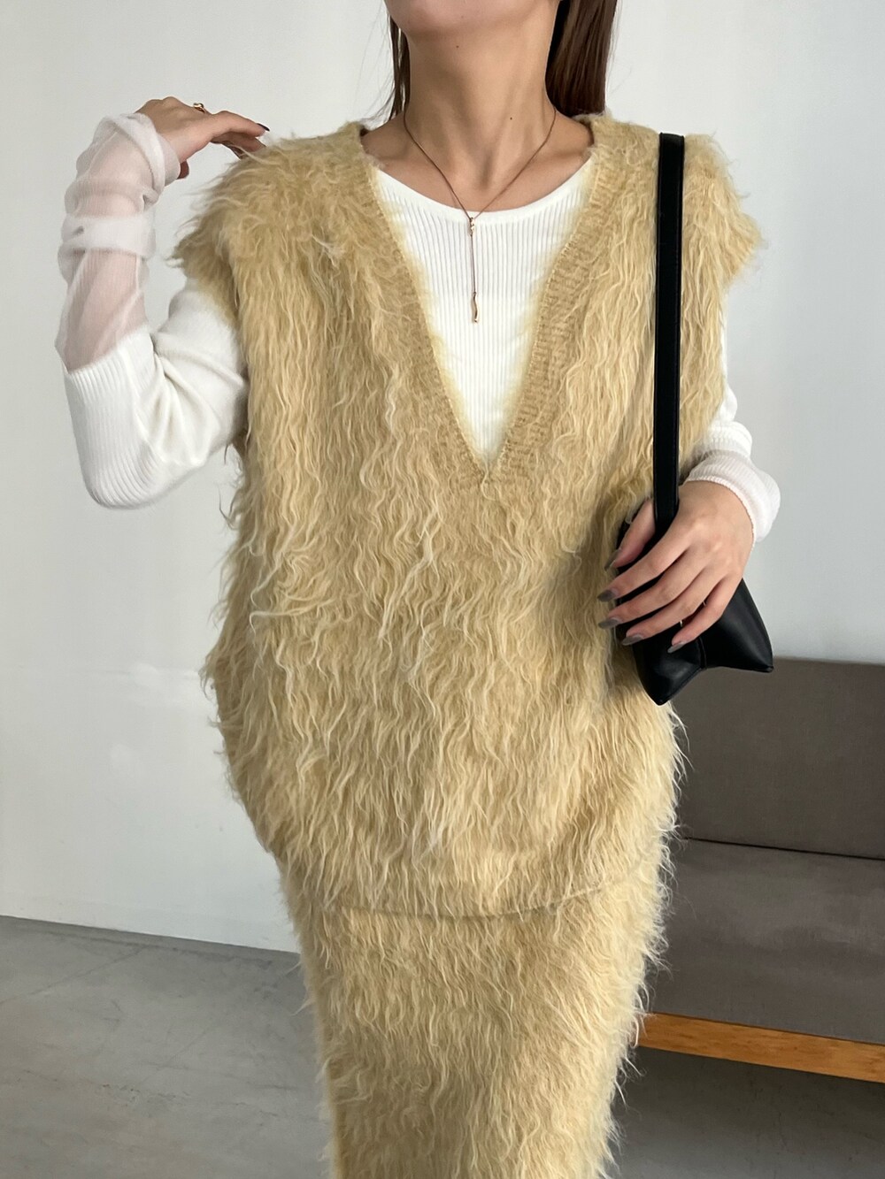 イエロー系のスカート、ホワイト系のニット/セーター、イエロー系のニット/セーターを着用したレディースの秋コーディネートの3枚目の写真