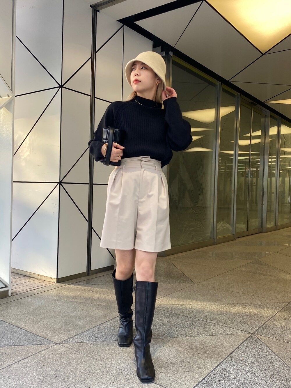 ブラック系のニット/セーター、ブラック系のブーツ、ブラック系のトートバッグを着用したレディースの冬コーディネートの2枚目の写真