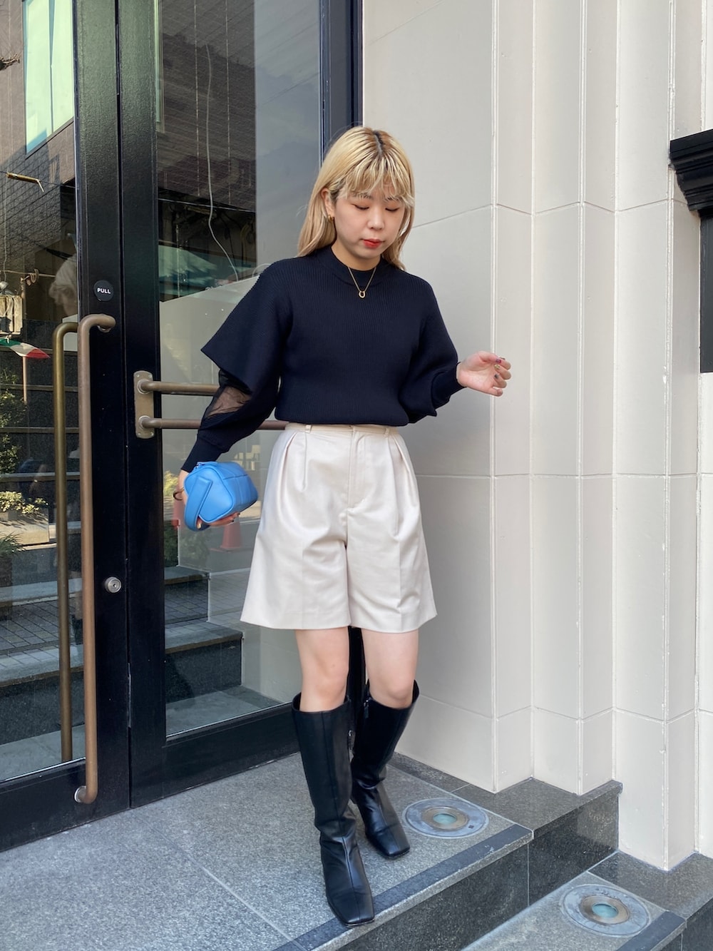 ブラック系のニット/セーター、ホワイト系のその他パンツ、ブラック系のブーツを着用したレディースの冬コーディネートの4枚目の写真